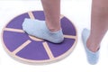 Woman`s foot on Wooden Wobble Balance Board Exercise Core Fitness Trainer for Workout, Fitness, Balance Exercise & Rehabilitation