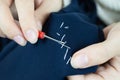 Woman`s hads with seam ripper ripping stitches on fabric. Hands sewing, repairing clothes. Tailoring, homecraft concept Royalty Free Stock Photo