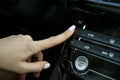 Driver`s hand adds temperature on the climate control inside the car