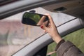 Woman`s hand adjusts the rearview mirror in the car close up Royalty Free Stock Photo