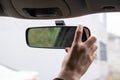 Woman`s hand adjusts the rearview mirror in the car close up Royalty Free Stock Photo