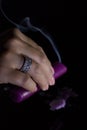 A woman`s hand with a beautiful silver ring holds a smoking purple candle Royalty Free Stock Photo