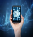 Woman s hand with bitcoin icon on smartphone Royalty Free Stock Photo