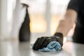 A hand in black gloves holds a microfiber cleaning cloth and a spray with sterilizing make disinfection for good hygiene Royalty Free Stock Photo