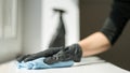 A hand in black gloves holds a microfiber cleaning cloth and a spray with sterilizing make disinfection for good hygiene Royalty Free Stock Photo