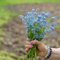 Woman\'s hand with blue flowers, bracelet with pearls