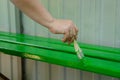 A woman`s hand with a brush paints wooden boards with green paint. Repair concept Royalty Free Stock Photo