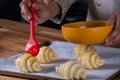 woman's hand brushing beaten egg on croissants to put them in the oven Royalty Free Stock Photo