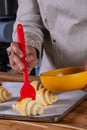 woman's hand brushing beaten egg on croissants to put them in the oven Royalty Free Stock Photo