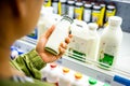 Woman`s hand buying milk in the supermarket. Woman choosing milk in dairy product department