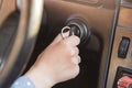 Woman`s hand on car`s key, tries to start engine, turn on key in keyhole, auto`s panel and wheel in background. Key inserted in lo