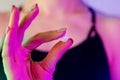 Woman`s hand close-up holding drug pill in neon light Royalty Free Stock Photo