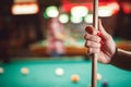 Woman`s hand with cue for playing billiard