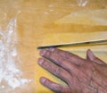 Woman`s hand cut with a knife a pasta sheet