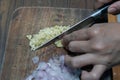 Woman's hand cut white onions on cutting board in home kitchen.