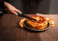 Woman`s hand cutting a roscon de reyes with a knife