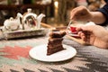 Woman`s hand cutting slice of chocolate cake Royalty Free Stock Photo