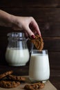A woman\'s hand dips cookies in milk. Organic breakfast of pastries