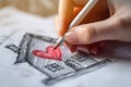 Woman's hand draws a house with red heart. Home sweet home concept. Royalty Free Stock Photo