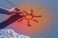 A woman`s hand draws the sun on the sand by the sea, the glow effect Royalty Free Stock Photo