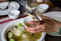 Woman`s hand filling a slice of Pompano fish soup into a small bowl. Pompano fish or Jack also known as Pampano for Filipinos o