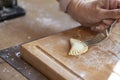 Woman`s hand folds dough pieces with spinach filling and closes the ravioli