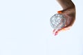 Woman`s hand with gel polish manicure holds in her palm a fashionable New Year or Christmas decoration - a shiny wire ball on a Royalty Free Stock Photo