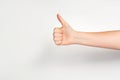 Woman`s hand gesturing thumbs up showing good or ok on light grey background