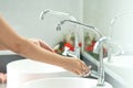 The woman`s hand is going to open the faucet to wash hands. To m Royalty Free Stock Photo