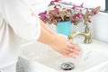 The woman`s hand is going to open the faucet to wash hands. To maintain cleanliness after entering the bathroom, the concept of Royalty Free Stock Photo