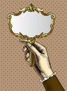 Woman`s hand with a gold retro mirror