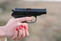 Woman's hand and a gun Royalty Free Stock Photo