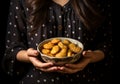 Woman\'s hand hold a bowl with delicious cookies. Christmas time. AI generated