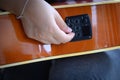 Woman`s hand holding of an acoustic guitar equalizer Royalty Free Stock Photo