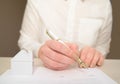 Woman`s hand holding ballpoint pen writing on agreement contract  paper sheet, applying for mortgage loan, filling in document tem Royalty Free Stock Photo