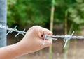 Woman's hand holding barbed wire fence for emotional captivity a Royalty Free Stock Photo