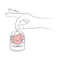 Woman\'s hand holding bird cage with heart locked in it. Heart in cage. Concept of love relationships