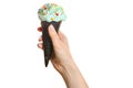 Woman`s hand holding black wafer cone with blue ice cream. Isola