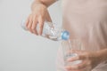 Woman`s hand holding a bottle of water Pouring water into a glass Royalty Free Stock Photo