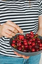 Woman`s hand holding bowl of fresh cherries Royalty Free Stock Photo