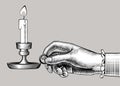 Woman`s hand holding a candlestick with burning candle