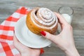 Woman`s hand holding cinnamon roll Royalty Free Stock Photo