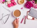 Woman`s hand holding cup with coffee on the table with different