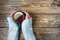 Woman`s hand holding cup of tea with lemon on a cold day. Wooden table. Top view Royalty Free Stock Photo