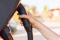 Woman`s hand holding an electric vehicle or EV car socket in a charging station. The future of the Automobile and Eco-friendly Royalty Free Stock Photo