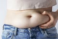 Woman`s hand holding excessive belly fat close-up, overweight concept Royalty Free Stock Photo