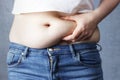 Woman`s hand holding excessive belly fat, overweight concept Royalty Free Stock Photo