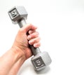 Woman`s hand holding a free weight dumbbell isolated on white