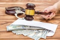 Woman`s Hand Holding Gavel Over Table With Money In Envelope And Handcuffs