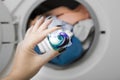 Woman`s hand holding gel pod. Capsule at washing maching  background. Clothes wash Royalty Free Stock Photo